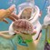 A girl in a Sea Trek helmet holds a sea urchin as a boy watches a man touch the spines